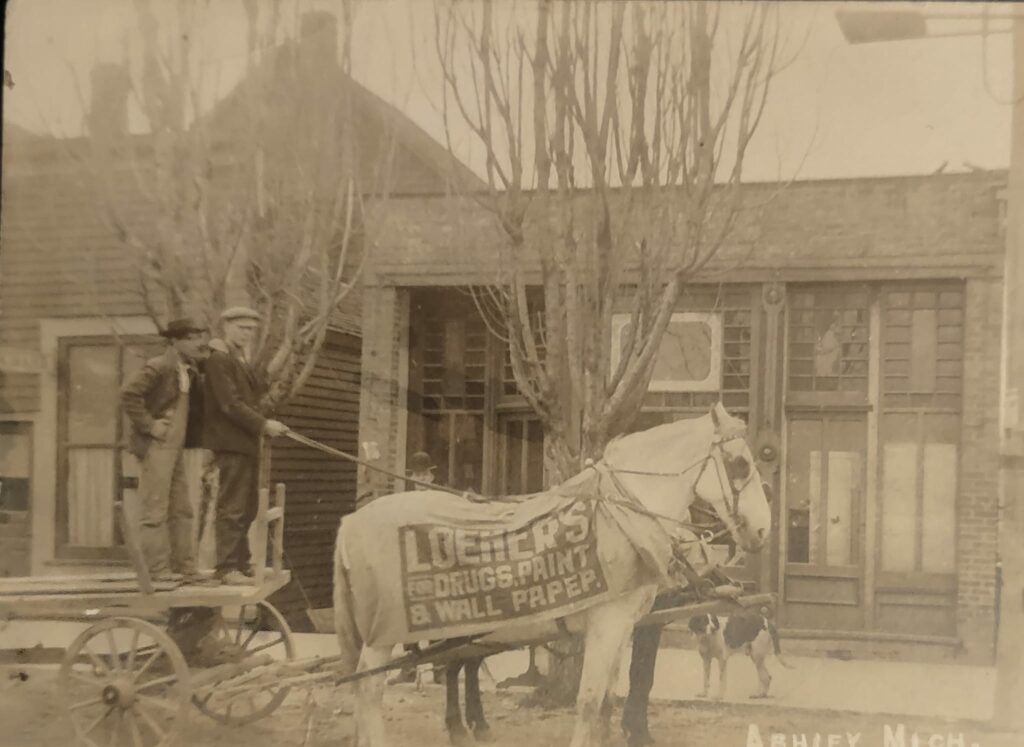 Historic horse-drawn cart, two men, advertisement banner.